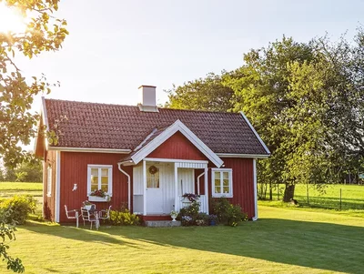 Bauernhaus auf grüner Wiese Kleines Bauernhaus steht auf grüner Wiese umgeben von Bäumen